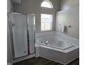 Bathroom with a large soaking tub, a separate glass-enclosed shower and a window for natural light at 6431 Furnas Rd, Indianapolis, IN 46221