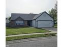 Well maintained single-story home featuring brick accents, a paved driveway and a two car garage at 6431 Furnas Rd, Indianapolis, IN 46221