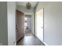 Welcoming entryway with a modern light fixture, hardwood floors, and a view to the front porch at 6602 Cobden Ct, Indianapolis, IN 46254