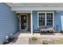 Inviting covered front porch with a stone accent wall, bench, and double-pane windows at 6602 Cobden Ct, Indianapolis, IN 46254