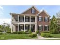 Charming two-story brick home featuring a welcoming front porch and well-manicured landscaping at 6655 Westminster Dr, Zionsville, IN 46077