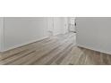 Hallway with modern wood-look flooring, neutral walls, and white trim leading to other rooms at 729 S Holmes Ave, Indianapolis, IN 46221