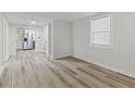 Bright living room with neutral walls and modern wood-look flooring leading to the kitchen at 729 S Holmes Ave, Indianapolis, IN 46221