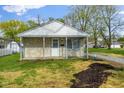 Charming single-story home featuring stone accents, a covered porch, and a well maintained lawn at 733 S Holmes Ave, Indianapolis, IN 46221