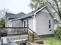This gray house has a wooden back deck with stairs down to the yard, and blue trim on the back door at 741 Walnut St, Franklin, IN 46131