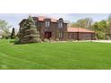 Beautiful two-story brick home with a red roof and large manicured front lawn at 7901 Oaklandon Rd, Indianapolis, IN 46236