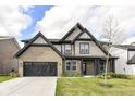 Charming two-story home with a brick and shingle exterior, black trim, and a well-manicured lawn at 9920 Deep Royal Way, Indianapolis, IN 46239