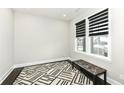 Bright and airy room featuring a geometric rug, a bench, and a window with modern blinds at 9920 Deep Royal Way, Indianapolis, IN 46239