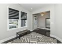 Bright room with geometric rug, bench seating, and view of entryway with decorative glass door and dark wood floors at 9920 Deep Royal Way, Indianapolis, IN 46239