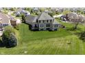 Aerial view highlighting the home's expansive backyard with lush green lawn and mature trees at 10138 Backstretch Row, Fishers, IN 46040