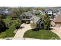 Aerial view of the front of the home showing off the gorgeous landscaping and welcoming two-car garage at 10138 Backstretch Row, Fishers, IN 46040