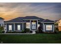 Beautiful home exterior featuring a well-maintained lawn, elegant landscaping, and a welcoming entrance with double doors at 10590 Geist View Dr, Fishers, IN 46055