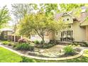 Landscaped front yard with mature trees and a quaint walkway leading to the entrance at 10919 Running Tide Ct, Indianapolis, IN 46236