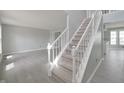 Bright entryway featuring a carpeted staircase, light gray walls and durable light gray laminate flooring at 11212 Bayridge E Cir, Indianapolis, IN 46236