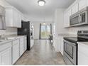Well-lit kitchen featuring white cabinets and stainless steel appliances at 11327 Cuyahoga Dr, Indianapolis, IN 46235