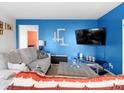 Cozy living room with blue accent wall, modern furniture, and a large screen television at 11327 Cuyahoga Dr, Indianapolis, IN 46235