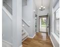 Inviting entryway featuring hardwood floors, neutral paint, and a staircase to the upper level at 12698 Whisper Way, Fishers, IN 46037