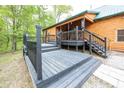 A black wood porch features steps leading to a log cabin, offering a cozy outdoor space at 1630 Hinson Rd, Martinsville, IN 46151