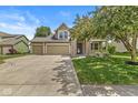 Inviting home with a three-car garage, stone details, covered porch, and lush green lawn, perfect for families at 19552 Wagon Trail Dr, Noblesville, IN 46060