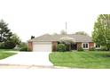 Charming single-story brick home with a well-manicured lawn and attached two car garage at 215 Fairway Ct, Franklin, IN 46131