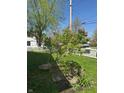 Well-maintained yard featuring a small tree, a stone planter, and a classic white picket fence at 25 N Wayburn St, Indianapolis, IN 46229