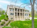 Beautiful backyard with multiple balconies, lush lawn, and stone facade on a multi-story home with ample natural light at 2733 Foxborough Dr, Greenwood, IN 46143