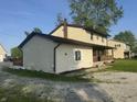 Two-story home showcases a covered porch and classic siding, enhanced by the surrounding green space at 3008 N Michigan Rd, Shelbyville, IN 46176
