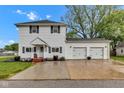 Charming two-story home featuring a two-car garage, a manicured lawn, and a cozy front porch at 301 S B St, Thorntown, IN 46071