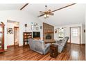 Inviting living room with a brick fireplace, wood floors, vaulted ceilings, and a ceiling fan at 3027 Ash Way, Lapel, IN 46051