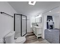 Modern bathroom features sleek glass shower, stylish vanity, and views to the living room fireplace at 3132 Indianapolis Ave, Indianapolis, IN 46208