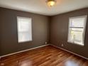 Cozy bedroom featuring hardwood floors, a light fixture and natural light from two windows at 3541 Orchard Ave, Indianapolis, IN 46218