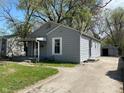 Features a well-maintained yard, covered front porch, and a detached garage with a long driveway at 3541 Orchard Ave, Indianapolis, IN 46218