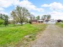 Scenic view of a single story home with a front porch, a driveway, and a grassy lawn at 389 E State Road 42, Mooresville, IN 46158