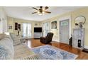 Comfortable living room with hardwood floors, ceiling fan, large windows, and neutral paint at 429 E Main St, Whiteland, IN 46184