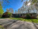 Charming single story home with brick and siding, circular driveway, and mature trees on a sunny lot at 4305 Lincoln Rd, Indianapolis, IN 46228