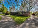 Charming single story home with brick and siding, circular driveway, and mature trees on a sunny lot at 4305 Lincoln Rd, Indianapolis, IN 46228