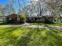 Charming single story home with brick and siding, circular driveway, and mature trees on a sunny lot at 4305 Lincoln Rd, Indianapolis, IN 46228