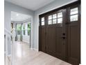 Bright entryway with hardwood floors, featuring a solid front door and views into the living spaces at 4904 Kessler Blvd N Dr, Indianapolis, IN 46228