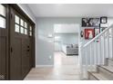 Welcoming foyer boasts hardwood floors, a staircase, and a view into the cozy living room at 4904 Kessler Blvd N Dr, Indianapolis, IN 46228