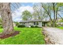 Quaint single-Gathering home with a well-kept lawn, mature tree, and convenient carport at 5141 Annette St, Indianapolis, IN 46208