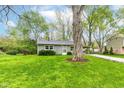 Charming single-story home with a well-manicured lawn and mature trees, offering great curb appeal at 5141 Annette St, Indianapolis, IN 46208