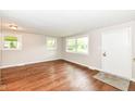 Bright living room with wood-look flooring, neutral walls, and large windows at 5141 Annette St, Indianapolis, IN 46208