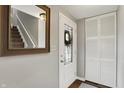 Inviting foyer with modern gray walls, front door with decorative window, closet, and dark wood-look floors at 5341 Armstrong Dr, Indianapolis, IN 46237