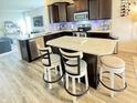 Modern kitchen featuring a granite island with stylish bar stools, stainless steel appliances, and sleek dark cabinetry at 5839 W Commonview Dr, McCordsville, IN 46055