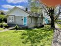 Charming single-story home with stone facade, well-maintained lawn, and bright blue front door at 5841 E Julian Ave, Indianapolis, IN 46219