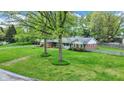 Lovely ranch home with a well-manicured lawn and mature trees offering shade and enhancing its appeal at 7804 Wawasee Dr, Indianapolis, IN 46250