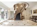 Elegant foyer with a curved staircase, marble floors, and custom millwork at 8103 N Pennsylvania St, Indianapolis, IN 46240