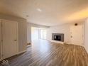 Open-concept living room features laminate floors, a fireplace, and natural light at 8350 Paso Del Norte Ct, Indianapolis, IN 46227