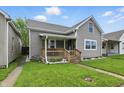 Charming home featuring a covered front porch, manicured lawn, and neutral siding at 842 Miller Ave, Shelbyville, IN 46176
