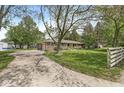 A single-story brick home with an extended driveway and a lush green lawn on a sunny day at 8814 E 146Th St, Noblesville, IN 46060